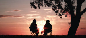 Family Reunion: Two people sitting at sunset.